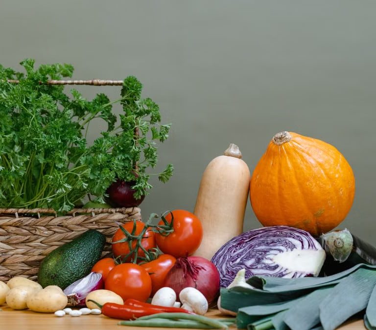 A vibrant display of fresh vegetables including tomatoes, squash, and parsley.
