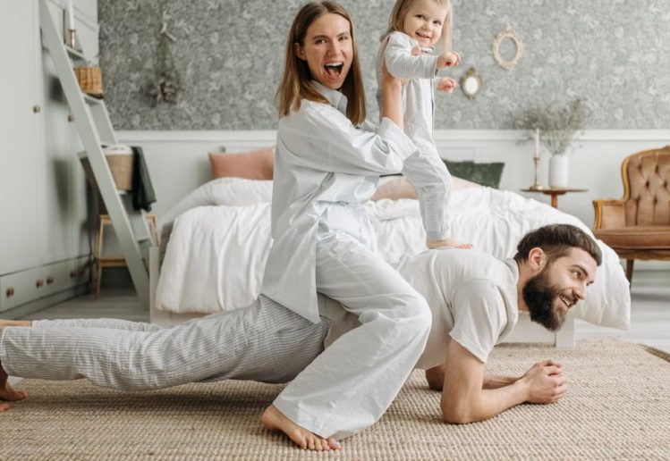 A cheerful family enjoys bonding and playing together on a cozy morning in a stylish bedroom.