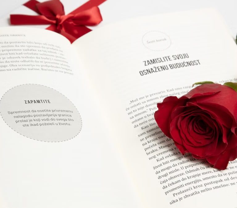 Elegant red rose on an open book with a red ribbon, symbolizing romance and literature.